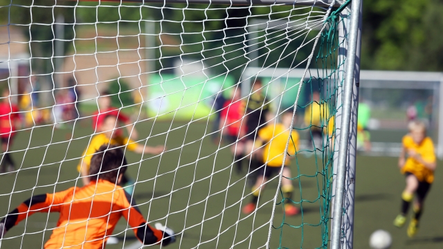 Young boys play football match