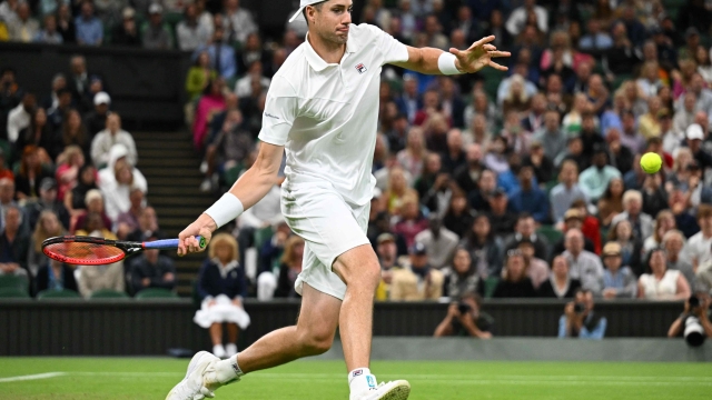 (FILES) US John Isner returns the ball to Britain's Andy Murray during their men's singles tennis match on the third day of the 2022 Wimbledon Championships at The All England Tennis Club in Wimbledon, southwest London, on June 29, 2022. Big-serving American John Isner, preparing for his 17th US Open start, said August 23, 2023 in a social media post that he will retire from professional tennis after the final  Grand Slam of the year. (Photo by SEBASTIEN BOZON / AFP) / RESTRICTED TO EDITORIAL USE