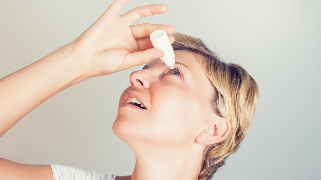 a woman using eye drops in eyes