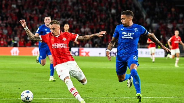 PSV Eindhoven's Dutch midfielder Noa Lang (L) fights for the ball with Rangers FC's English defender James Tavernier (R) during the UEFA Champions League play-off football match between PSV Eindhoven and Rangers FC at The Phillips stadium in Eindhoven, on August 30, 2023. (Photo by Olaf Kraak / ANP / AFP) / Netherlands OUT
