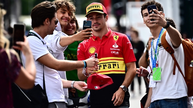 Fans take selfies with Ferrari's Monegasque driver Charles Leclerc at the paddock at the Monza Circuit ahead of the Italy's Formula One Grand Prix, in Monza northern Italy, on August 31,  2023. The 2023 Italy's Grand Prix will take place on September 3, 2023. (Photo by Marco BERTORELLO / AFP)