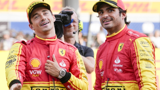 Ferrari driver Carlos Sainz of Spain, right, celebrates his pole position with third placed Ferrari driver Charles Leclerc of Monaco after the qualifying session ahead of Sunday's Formula One Italian Grand Prix auto race, at the Monza racetrack, in Monza, Italy, Saturday, Sept. 2, 2023. (AP Photo/Luca Bruno)