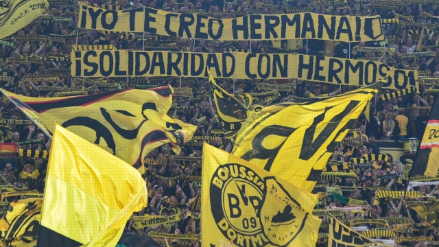 Dortmund fans wave flags and hold up banners in solidarity with Spain's player Jennifer Hermoso prior to the German first division Bundesliga football match between BVB Borussia Dortmund and FC Heidenheim in Dortmund, western Germany on September 1, 2023. (Photo by UWE KRAFT / AFP) / DFL REGULATIONS PROHIBIT ANY USE OF PHOTOGRAPHS AS IMAGE SEQUENCES AND/OR QUASI-VIDEO    ALTERNATIVE CROP