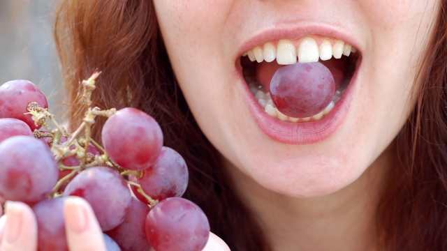 The women eats grapes.