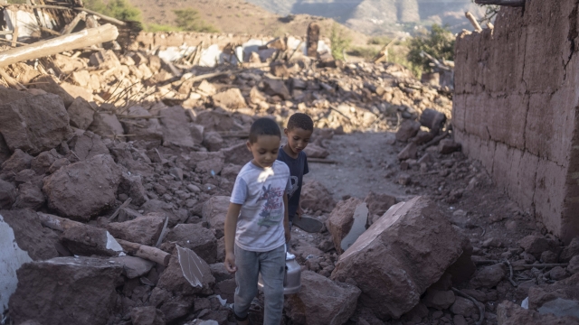Moroccan boys, Rayan and Ali walk amidst the rubble of their home which was damaged by the earthquake, in Ijjoukak village, near Marrakech, Morocco, Saturday, Sept. 9, 2023. A rare, powerful earthquake struck Morocco, sending people racing from their beds into the streets and toppling buildings in mountainous villages and ancient cities not built to withstand such force. (AP Photo/Mosa'ab Elshamy)
