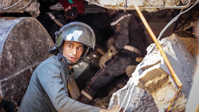 A rescuer searches for survivors under the rubble of a house destroyed in an earthquake in Moulay Brahim, Al-Haouz province, on September 9, 2023. Morocco's deadliest earthquake in decades has killed at least 1000 people, officials said on September 9, causing widespread damage and sending terrified residents and tourists scrambling to safety in the middle of the night. (Photo by FADEL SENNA / AFP)