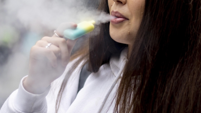 epa10663273 A person uses a single-use vaping product in London, Britain, 30 May 2023. The UK government has announced it is cracking down on retailers providing free vape samples to children. The government's new proposals include rules on fines for shops selling illicit vapes to children under 18-years-old.  EPA/TOLGA AKMEN
