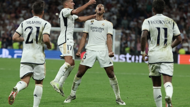 Real Madrid's English midfielder #5 Jude Bellingham celebrates with teammates scoring his team's first goal during the UEFA Champions League 1st round day 1 group C football match between Real Madrid and Union Berlin at the Santiago Bernabeu stadium in Madrid on September 20, 2023. (Photo by Thomas COEX / AFP)