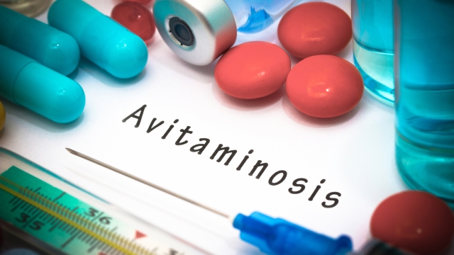Avitaminosis - diagnosis written on a white piece of paper. Syringe and vaccine with drugs.