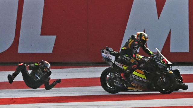 Mooney VR46 Racing's Italian rider Luca Marini (L) crashes as Mooney VR46 Racing Team's Italian rider Marco Bezzecchi rides past during the sprint race of the Indian MotoGP Grand Prix at the Buddh International Circuit in Greater Noida on the outskirts of New Delhi, on September 23, 2023. (Photo by Money SHARMA / AFP)