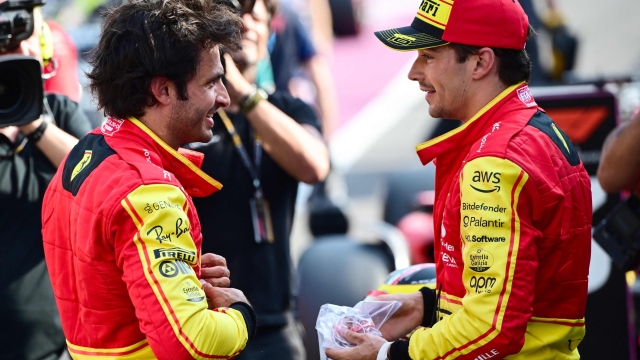 TOPSHOT - First placed Ferrari's Spanish driver Carlos Sainz Jr (L) and third placed Ferrari's Monegasque driver Charles Leclerc celebrate after the qualifying session, ahead of the Italian Formula One Grand Prix at Autodromo Nazionale Monza circuit, in Monza on September 2, 2023. (Photo by Marco BERTORELLO / AFP)