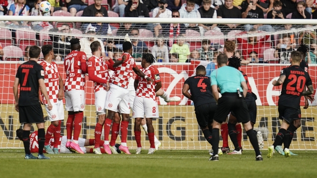 Leverkusen's Alejandro Grimaldo, right, scores his side's second goal on a free-kick during a German Bundesliga soccer match between FSV Mainz 05 and Bayer Leverkusen, at the Mewa Arena in Mainz, Germany, Saturday Sept. 30, 2023. (Uwe Anspach/dpa via AP)