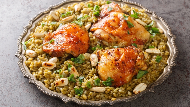 Plate of Traditional Syrian Freekeh with roasted chicken and almond closeup on the table. Horizontal