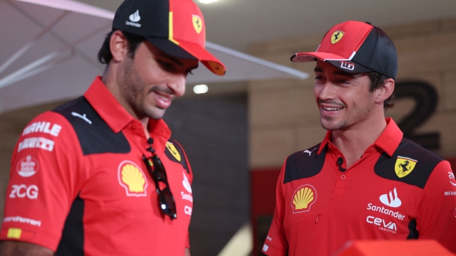 Ferrari's Spanish driver Carlos Sainz Jr (L) and Ferrari's Monegasque driver Charles Leclerc speak together at the circuit ahead of the Formula One Qatar Grand Prix at the Losail Circuit on October 5, 2023. (Photo by Giuseppe CACACE / AFP)