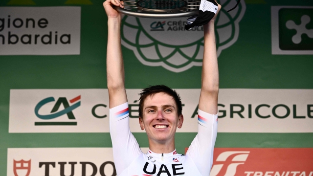 UAE Team Emirates team's Slovenian rider Tadej Pogacar lifts the trophy on the podium after winning the 117th edition of the Giro di Lombardia (Tour of Lombardy), a 238km cycling race from Como to Bergamo on October 7, 2023. (Photo by Marco BERTORELLO / AFP)