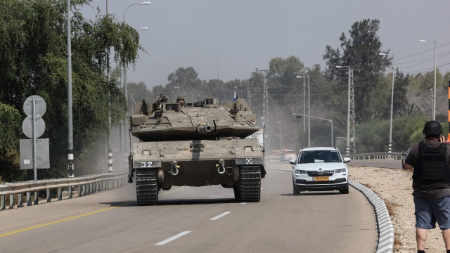 An Israeli tank drives on a road near Sderot on October 8, 2023. Israel's prime minister of October 8 warned of a "long and difficult" war, as fighting with Hamas left hundreds killed on both sides after a surprise attack on Israel by the Palestinian militant group. (Photo by JACK GUEZ / AFP)