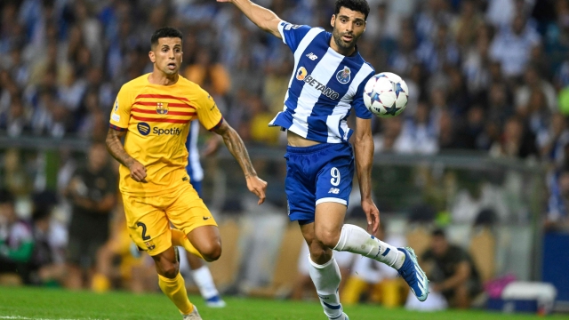 Barcelona's Portuguese defender #02 Joao Cancelo fights for the ball with FC Porto's Iranian forward #09 Mehdi Taremi during the UEFA Champions League 1st round day 2 group H football match between FC Porto and FC Barcelona at the Dragao stadium in Porto on October 4, 2023. (Photo by Patricia DE MELO MOREIRA / AFP)