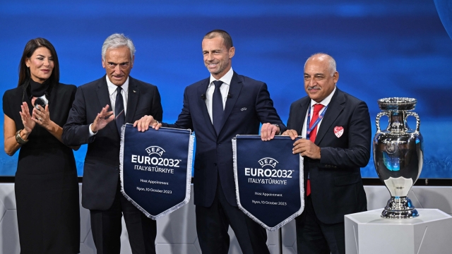 President of the Turkish Football Federation (TFF) Mehmet Buyukeksi (R), Italian TV host and commentator Ilaria D'Amico (L), President of the Italian Football Federation (FIGC) Gabriele Gravina (2ndL) and UEFA president Aleksander Ceferin (C) pose with pennants after Turkey and Italy were elected to host the Euro 2032 fooball tournament during the announcement ceremony at the UEFA headquarters in Nyon on October 10, 2023. (Photo by Fabrice COFFRINI / AFP)