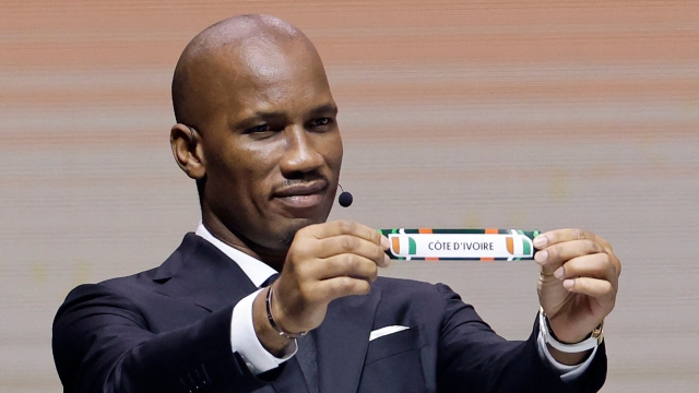 Former Ivorian footballer Didier Drogba shows the paper slip of Ivory Coast during the Africa Cup of Nations (CAN) 2024 official draw at Parc des Expositions in Abidjan on October 12, 2023. (Photo by WIKUS DE WET / AFP)