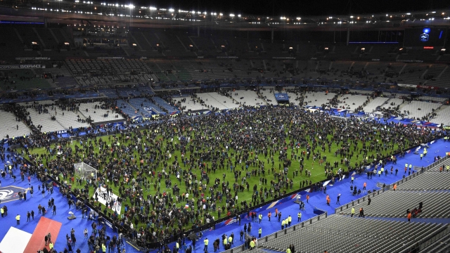 Spectators gather on the pitch of the Stade de France stadium following the friendly football match between France and Germany in Saint-Denis, north of Paris, on November 13, 2015, after a series of gun attacks occurred across Paris as well as explosions outside the national stadium where France was hosting Germany. At least 18 people were killed, with at least 15 people had been killed at the Bataclan concert hall in central Paris, only around 200 metres from the former offices of Charlie Hebdo which were attacked by jihadists in January.  AFP PHOTO / FRANCK FIFE