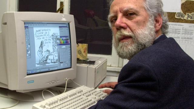 L'Unita's cartoonist Sergio Staino finishes the front-page cartoon  at his seat in the newsroom in Rome, Tuesday, March 27 2001. L'Unita' will  be back on the newstands on Wednesday after being out for eight months. (AP Photo/Corrado Giambalvo)