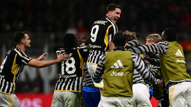 Juventus' Italian midfielder #05 Manuel Locatelli (hidden) celebrates with teammates after scoring the team's first goal during the Italian Serie A football match between Milan and Juventus at San Siro Stadium, in Milan on October 22, 2023. (Photo by Marco BERTORELLO / AFP)