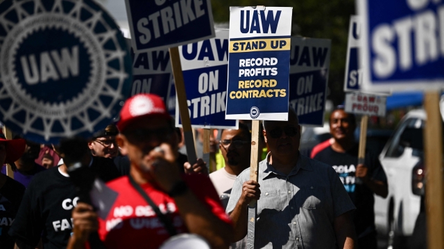 (FILES) (FILES) Labor supporters and members of the United Auto Workers union (UAW) Local 230 march along a picket line during a strike outside of the Stellantis Chrysler Los Angeles Parts Distribution Center in Ontario, California, on September 26, 2023. An auto workers strike in the United States expanded October 11, 2023 with 8,700 more employees walking off their jobs, said the United Automobile Workers (UAW) union, as a deal with major automakers remained elusive. (Photo by Patrick T. Fallon / AFP)