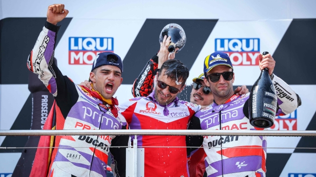 (L-R) Winner Ducati Pramac Racing Team's Spanish rider Jorge Martin, Prima Pramac Racing Italian team director Gino Borsoi, second-placed Ducati Lenovo Team's Italian rider Francesco Bagnaia and third-placed Ducati Pramac Racing Team's French rider Johann Zarco celebrate on the podium after the MotoGP German motorcycle Grand Prix at the Sachsenring racing circuit in Hohenstein-Ernstthal near Chemnitz, eastern Germany, on June 18, 2023. (Photo by Ronny Hartmann / AFP)