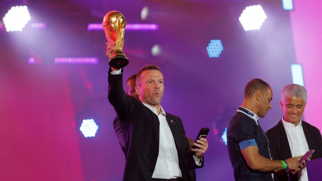 German former football player Lothar Matthaus poses on stage with the trophy during the FIFA Fan Festival opening day at Al Bidda park in Doha on November 19, 2022, ahead of the Qatar 2022 World Cup football tournament. (Photo by Odd ANDERSEN / AFP)