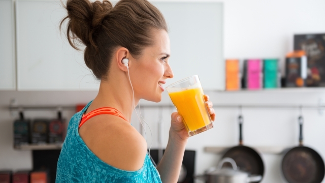 In her modern kitchen, a woman in profile is about to drink her freshly-made smoothie, which is packed with vitamins. A healthy lifestyle is so much fun.