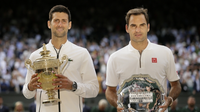 FILE - Serbia's Novak Djokovic, left, and Switzerland's Roger Federer pose with the trophies after the men's singles final match of the Wimbledon Tennis Championships in London, Sunday, July 14, 2019. He's already been No. 1 for more weeks than any man or woman in the half-century of computerized rankings. Now he will try to pull even with Roger Federer by earning title No. 8 at the oldest of the four Grand Slam tennis tournaments. (AP Photo/Tim Ireland, File)