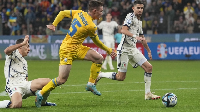 Ukraine's Vitaliy Mykolenko, centre, is challenged by Italy's Jorginho, right, during the Euro 2024 group C qualifying soccer match between Ukraine and Italy at the BayArena in Leverkusen, Germany, Monday, Nov. 20, 2023. (AP Photo/Martin Meissner)