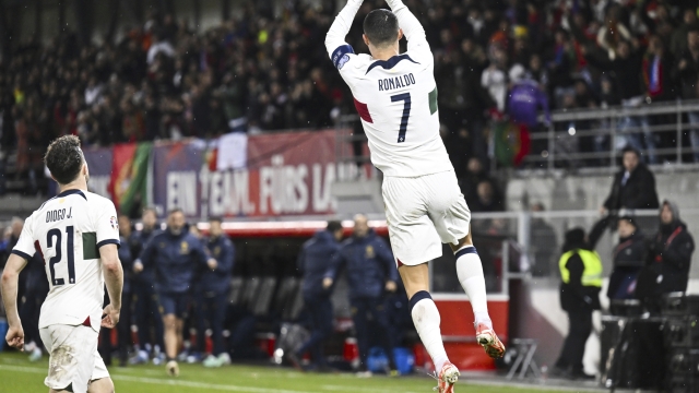 Portugal's Cristiano Ronaldo, right, celebrates after scoring their side's opening goal of the game during the UEFA Euro 2024 group J qualifying soccer match between Liechtenstein and Portugal, in Vaduz, Liechtenstein, Thursday, Nov. 16, 2023. (Gian Ehrenzeller/Keystone via AP)