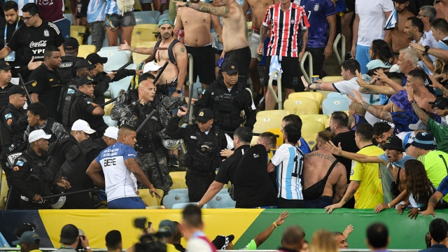 TOPSHOT - Fans of Argentina clash with Brazilian police before the start of the 2026 FIFA World Cup South American qualification football match between Brazil and Argentina at Maracana Stadium in Rio de Janeiro, Brazil, on November 21, 2023. (Photo by CARL DE SOUZA / AFP)
