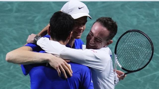 Captain of Team Italy Filippo Volandri, right, hugs Italy's Janik Sinner, centre, and Italy's Lorenzo Sonego after they won their Davis Cup quarter-final tennis match against Netherlands' Tallon Griekspoor and Netherlands' Wesley Koolhof in Malaga, Spain, Thursday, Nov. 23, 2023. (AP Photo/Manu Fernandez)