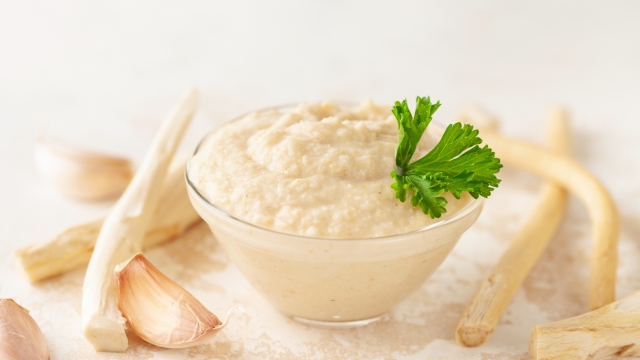 Horseradish sauce in a jar and ingredients on a white background.