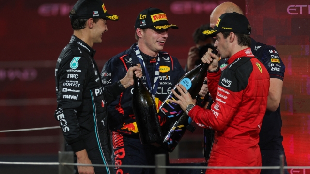 Red Bull Racing's Dutch driver Max Verstappen (C), Ferrari's Monegasque driver Charles Leclerc (R) and Mercedes' British driver George Russell celebrate on the podium after the Abu Dhabi Formula One Grand Prix at the Yas Marina Circuit in the Emirati city on November 26, 2023. (Photo by Giuseppe CACACE / AFP)