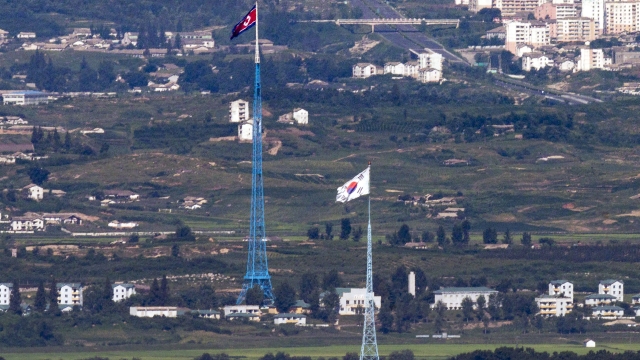 FILE - Flags of North Korea, rear, and South Korea, front, flutter in the wind as pictured from the border area between two Koreas in Paju, South Korea, on Aug. 9, 2021. South Korea says it has postponed the planned launch of its first military spy satellite set for this Thursday, Nov. 30. South Korea's first domestically built spy satellite had been scheduled to lift off aboard SpaceX?s Falcon 9 rocket from California?s Vandenberg Air Force Base.(Im Byung-shik/Yonhap via AP, File)