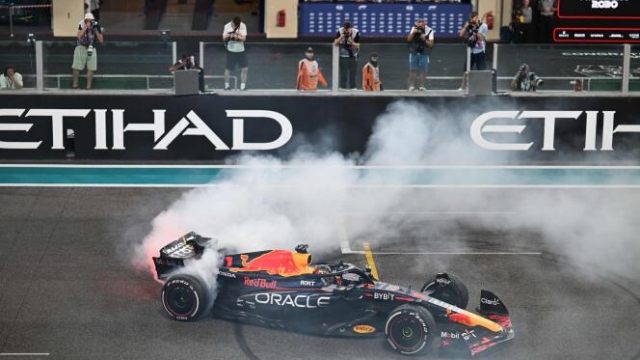 TOPSHOT - Red Bull Racing's Dutch driver Max Verstappen performs a burnout after winning the Abu Dhabi Formula One Grand Prix at the Yas Marina Circuit in the Emirati city on November 26, 2023. (Photo by Jewel SAMAD / AFP)