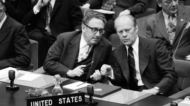 (FILES) US Secretary of State Henry Kissinger (L) speaks with US President Gerald Ford during the OTAN summit in Brussels on May 30, 1975. Former US secretary of state Henry Kissinger, a key figure of American diplomacy in the post-World War II era, died November 29, 2023 at the age of 100, his association said. (Photo by AFP)