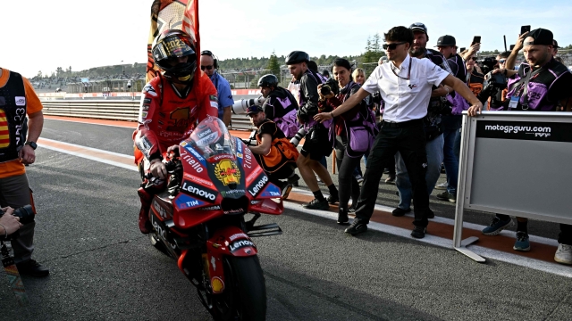 Ducati Italian rider Francesco Bagnaia enters the paddock after winning the MotoGP Valencia Grand Prix at the Ricardo Tormo racetrack in Cheste, on November 26, 2023. Italy's Francesco Bagnaia enjoyed a dream day as he retained his MotoGP world title and crowned it with victory in the final race of the season in Valencia today. The 26-year-old Ducati rider had been assured of the championship when his sole rival Jorge Martin crashed early in the race. (Photo by JAVIER SORIANO / AFP)