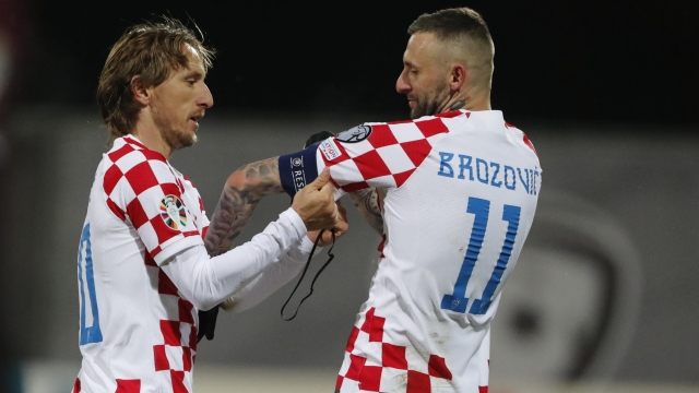 epa10983128 Luka Modric (L) of Croatia gives the captain's armband to Marcelo Brozovic during the UEFA EURO 2024 Group D qualification match between Latvia and Croatia in Riga, Latvia, 18 November 2023.  EPA/TOMS KALNINS
