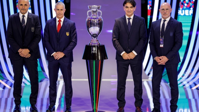 Italy's head coach Luciano Spalletti, Albania's head coach Sylvinho, Croatia's head coach Zlatko Dalic and Spain's head coach Luis de la Fuente pose next to the trophy after the final draw for the UEFA Euro 2024 European Championship football competition in Hamburg, northern Germany on December 2, 2023. (Photo by Odd ANDERSEN / AFP)