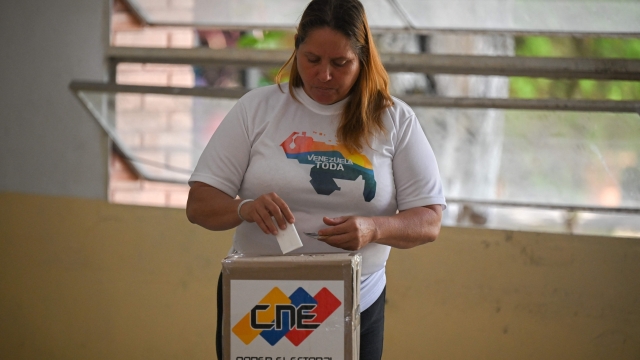 A woman votes at a polling station during a consultative referendum mock on Venezuelan sovereignty over the Esequibo, in Caracas on November 19, 2023. Next December 3 Venezuela will hold a referendum on whether to annex the Esequibo region -a contested oil-rich region administered by Guyana and which makes up more than two-thirds of its territory and home to 125,000 of its 800,000 citizens. The dispute over Esequibo dates back to 1899 when an arbitration tribunal fixed the border between Venezuela and Guyana -- a former colony of both Britain and the Netherlands. (Photo by Federico Parra / AFP)