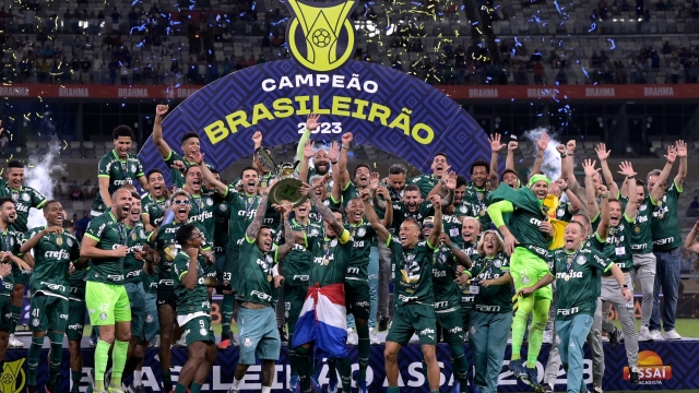 TOPSHOT - Palmeiras' players celebrate with the trophy after winning the Brazilian Championship following the football match between Cruzeiro and Palmeiras at Minerao stadium in Belo Horizonte, Brazil, on December 6, 2023. (Photo by DOUGLAS MAGNO / AFP)