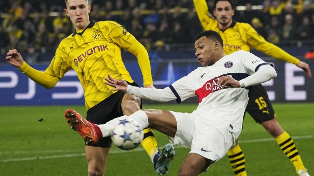 PSG's Kylian Mbappe, centre, and Dortmund's Nico Schlotterbeck, left, challenge for the ball during the Champions League Group F soccer match between Borussia Dortmund and Paris Saint-Germain at the Signal Iduna Park in Dortmund, Germany, Wednesday, Dec. 13, 2023. (AP Photo/Martin Meissner)