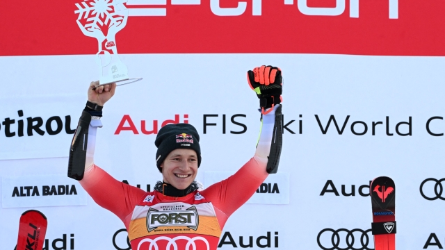 First placed Switzerland's Marco Odermatt celebrates on the podium of the men's Giant Slalom, during the FIS Alpine Ski World Cup in Alta Badia on December 17, 2023. (Photo by Tiziana FABI / AFP)