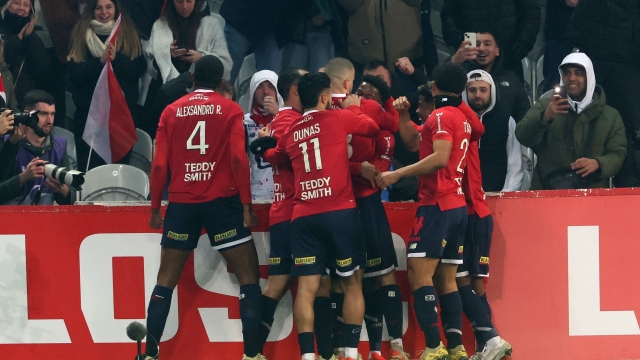 Lille's players celebrate after Lille's Canadian forward #09 Jonathan David scored their first goal during the French L1 football match between Lille LOSC and Paris Saint-Germain (PSG) at Stade Pierre-Mauroy in Villeneuve-d'Ascq, northern France on December 17, 2023. (Photo by DENIS CHARLET / AFP)