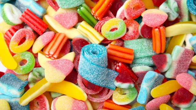 Tasty colorful jelly candies as background, above view