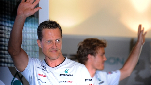 Mercedes driver Michael Schumacher (L) of Germany and his teammate and compatriot Nico Rosberg (R) wave during a meet the fans session ahead of the Formula One Malaysian Grand Prix in Kuala Lumpur on April 6, 2011. AFP PHOTO/ Saeed Khan